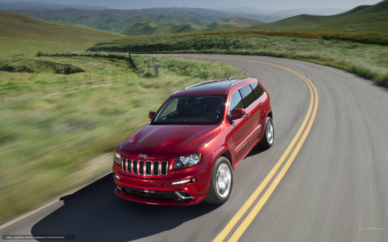 Red Jeep driving on a winding road