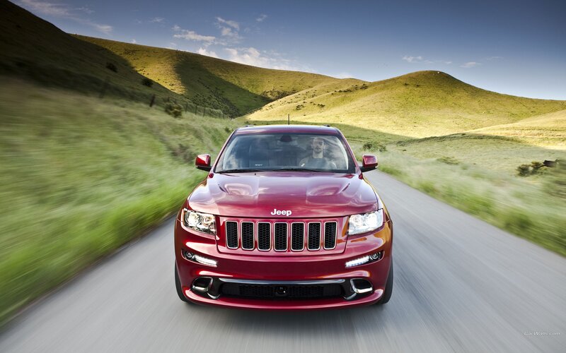 Red Jeep driving on country road