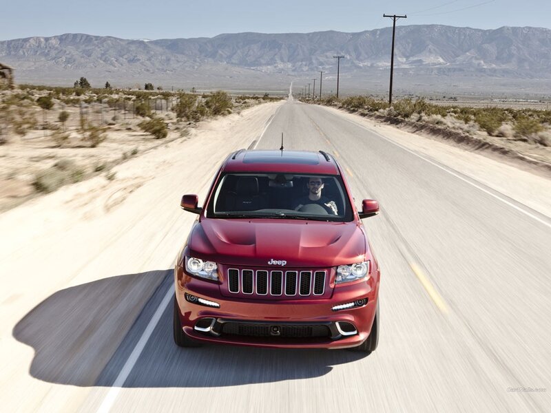 Red Jeep driving on desert road