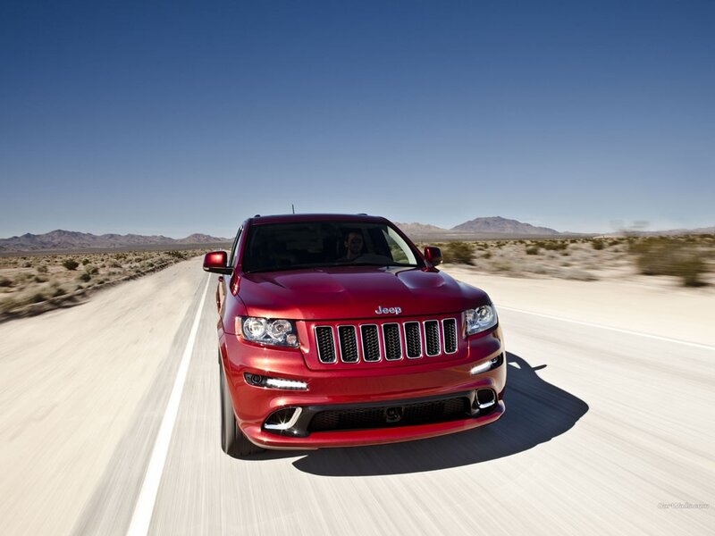 Red Jeep driving on desert road