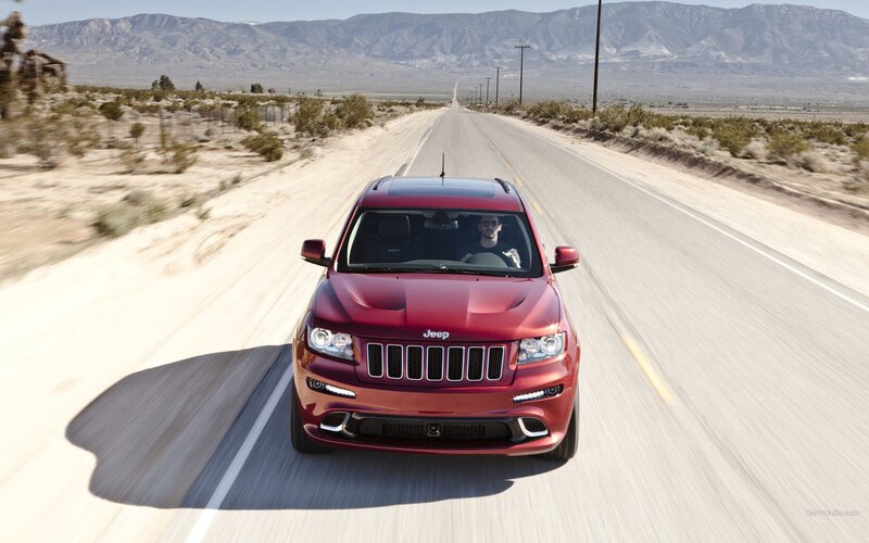 red jeep driving on desert road