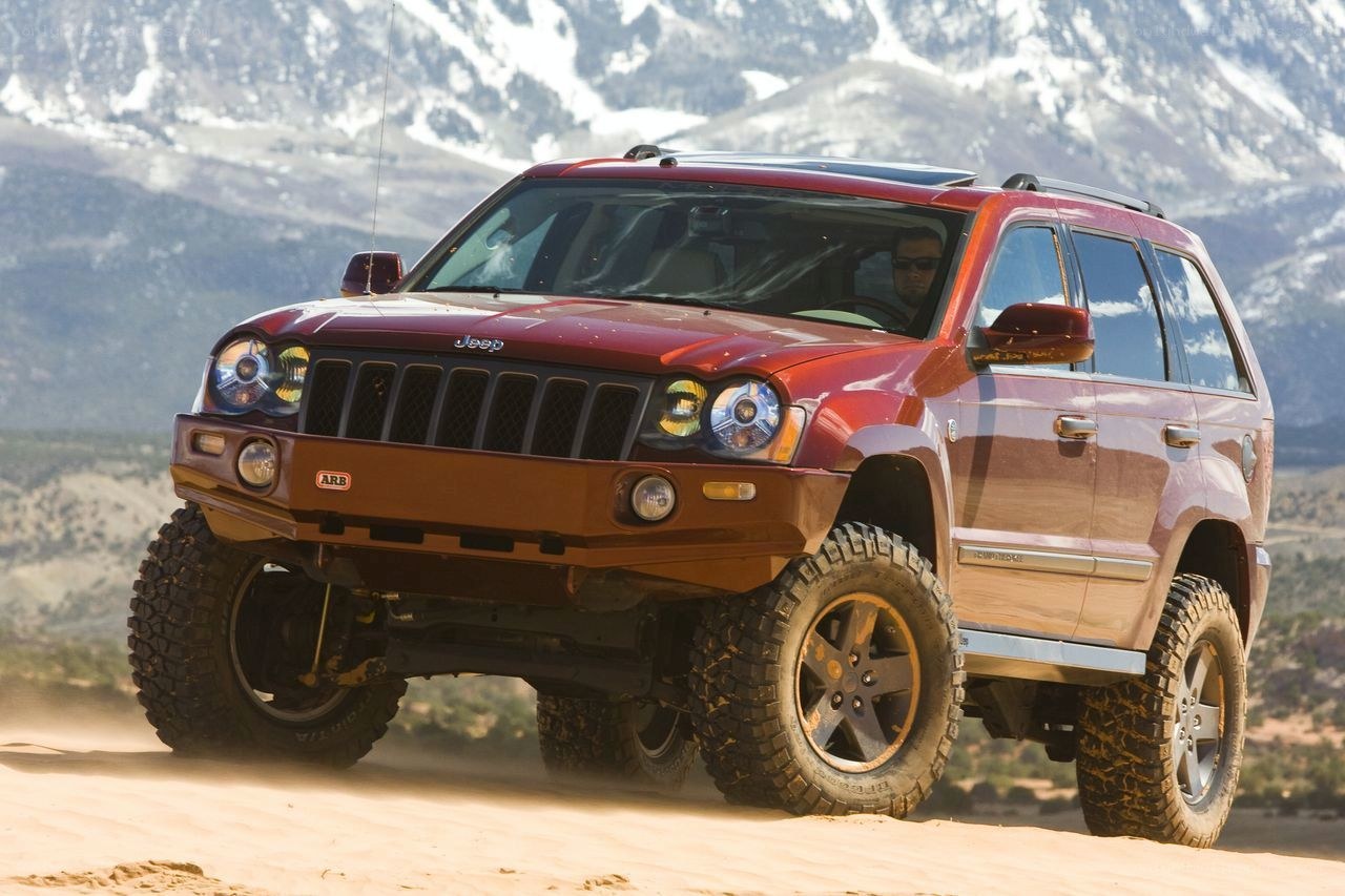 Red Jeep driving on sand