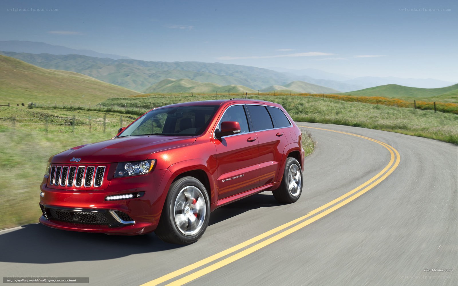 Red Jeep Grand Cherokee on a winding road