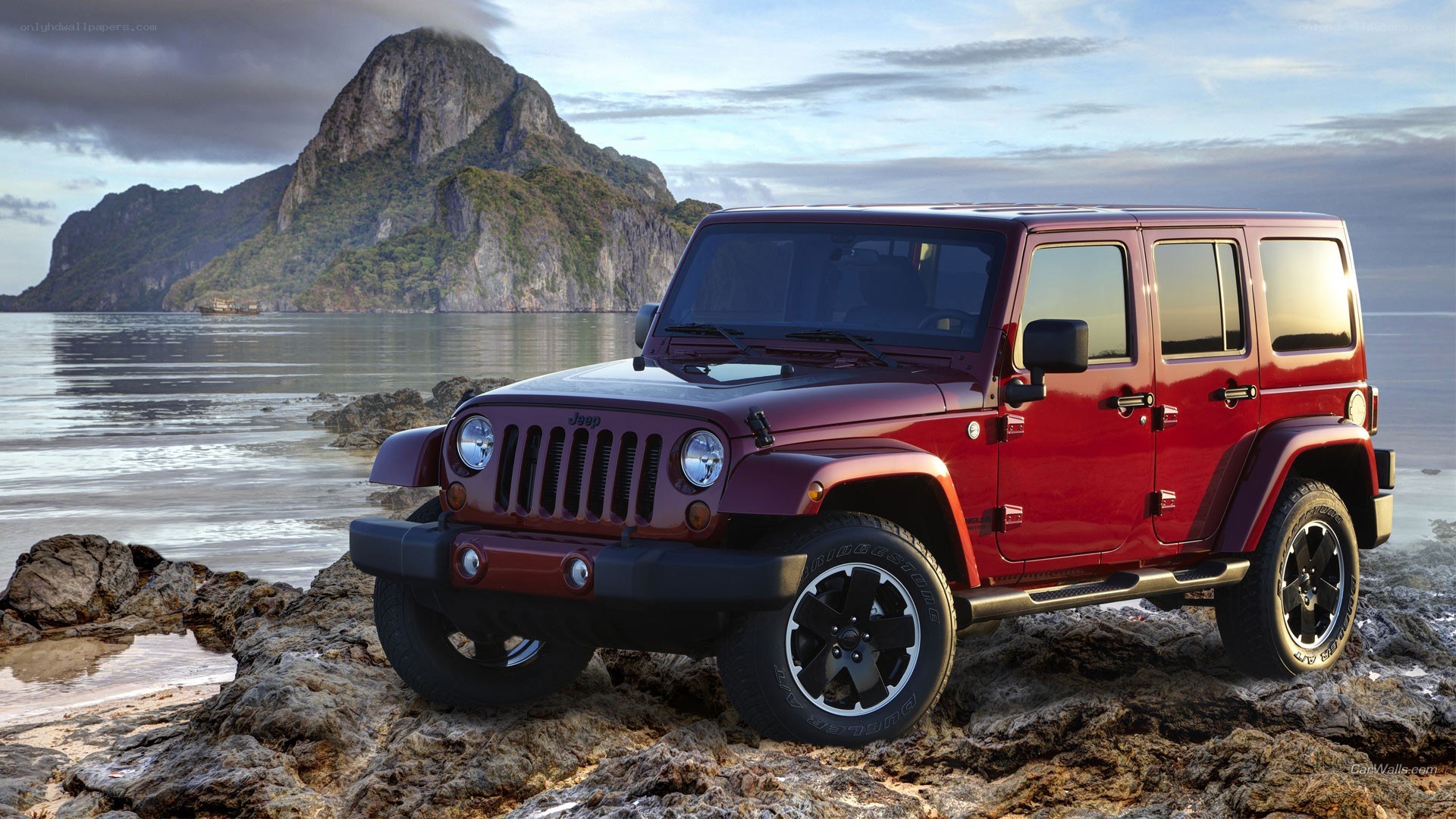 Red Jeep on rocky beach