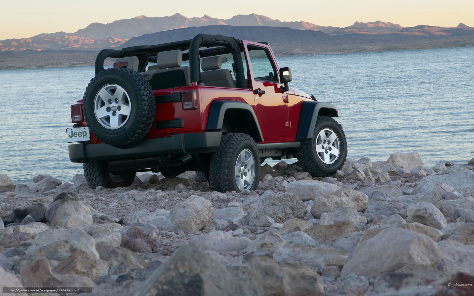 Red Jeep on rocky shore