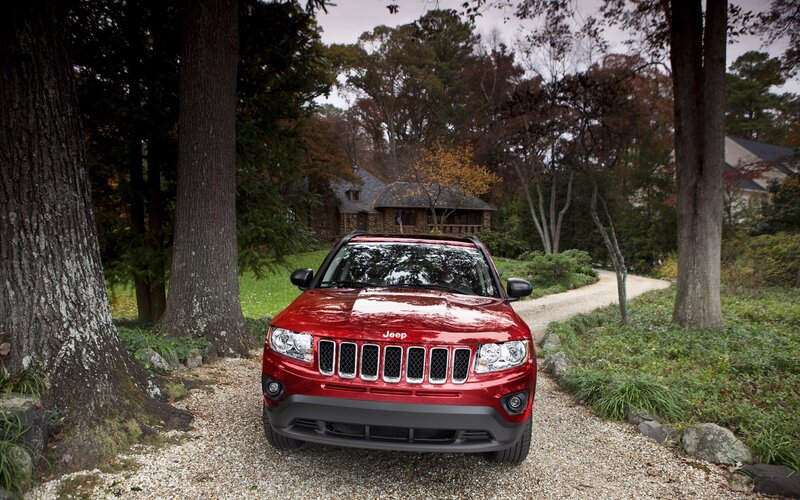 Red Jeep parked on gravel path