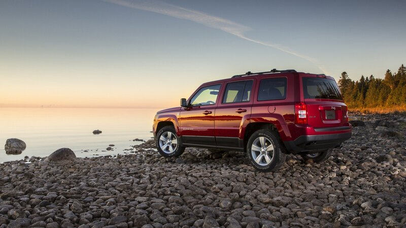 Red Jeep Patriot on a rocky shore