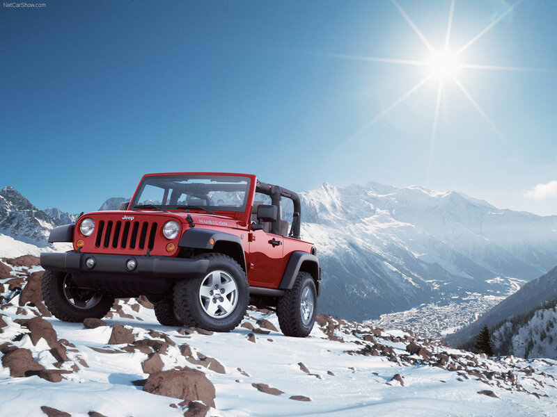 Red Jeep Rubicon in snowy mountains