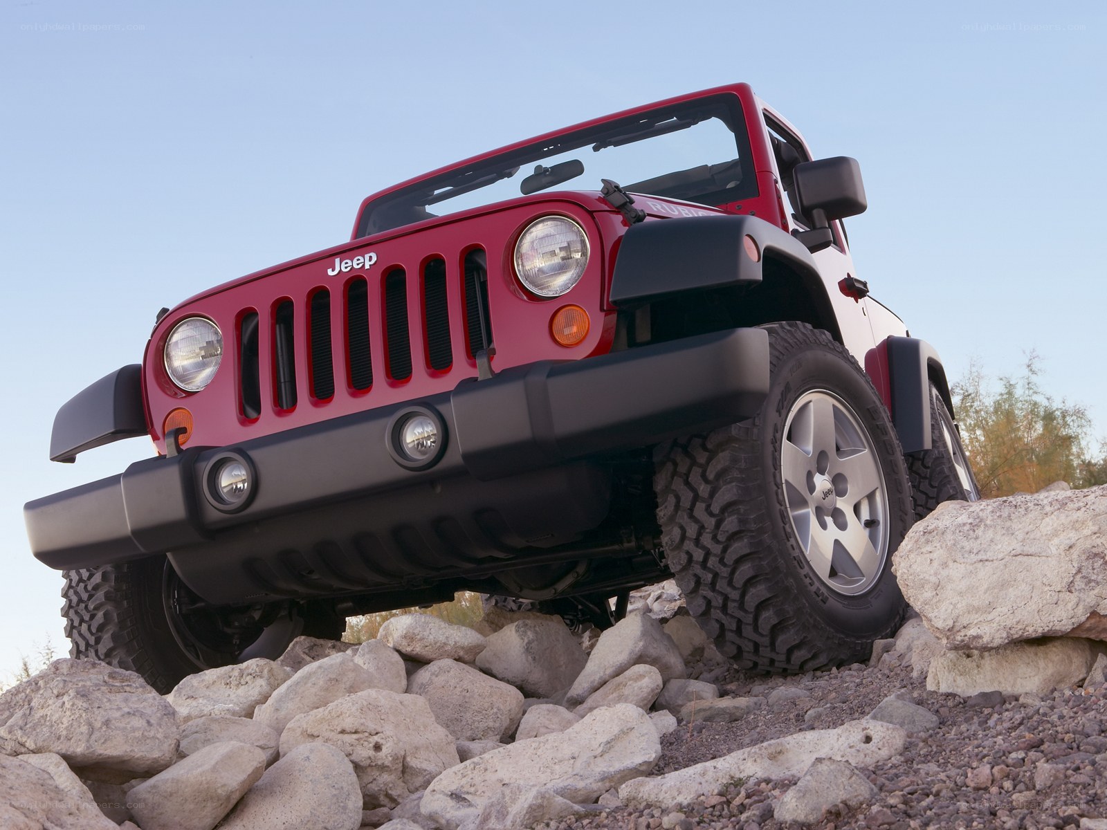 Red Jeep Wrangler on rocks