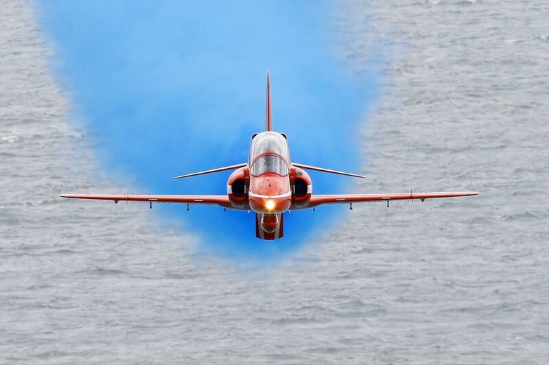 Red jet flying over water