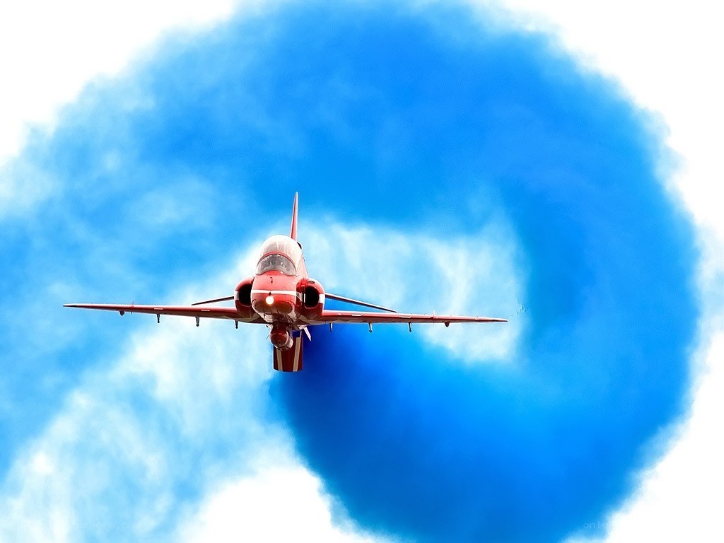 Red jet performing aerobatic maneuver