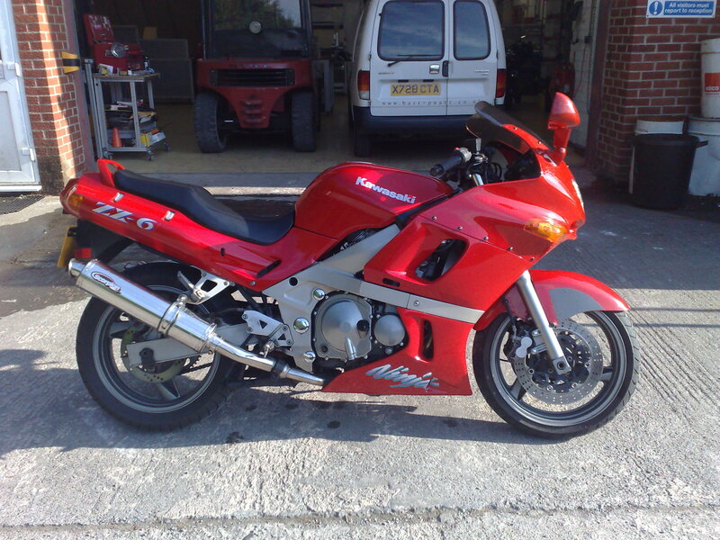Red Kawasaki motorcycle outside garage
