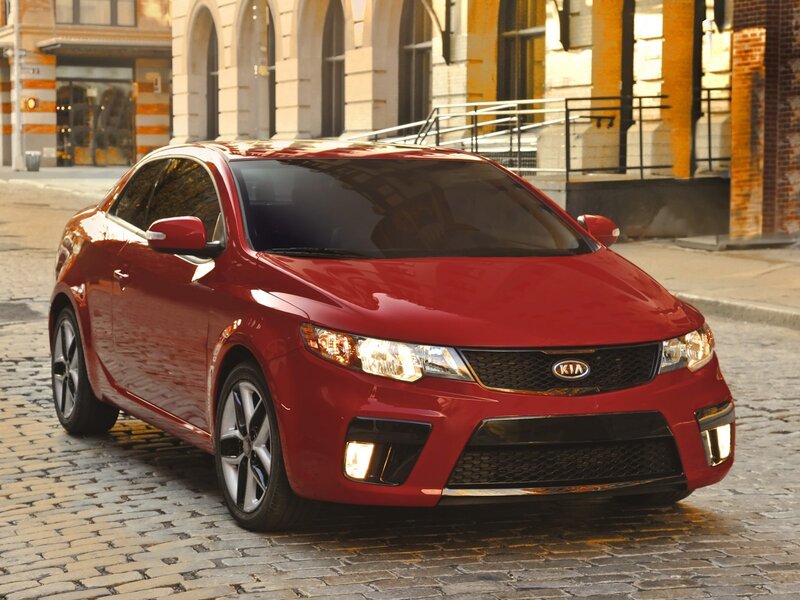 Red Kia Forte Koup on cobblestone street