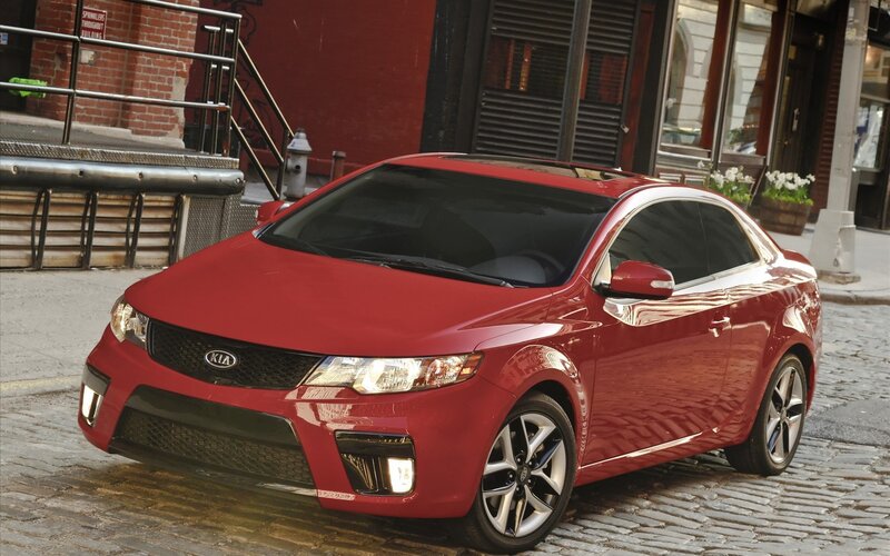 Red Kia Forte Koup on cobblestone street