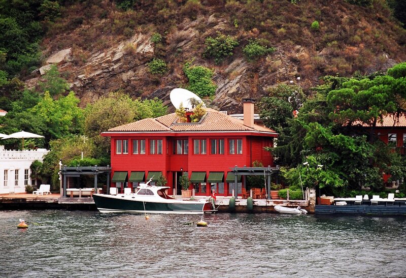 Red lakeside house with boat