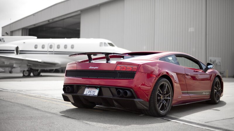 Red Lamborghini in front of private jet