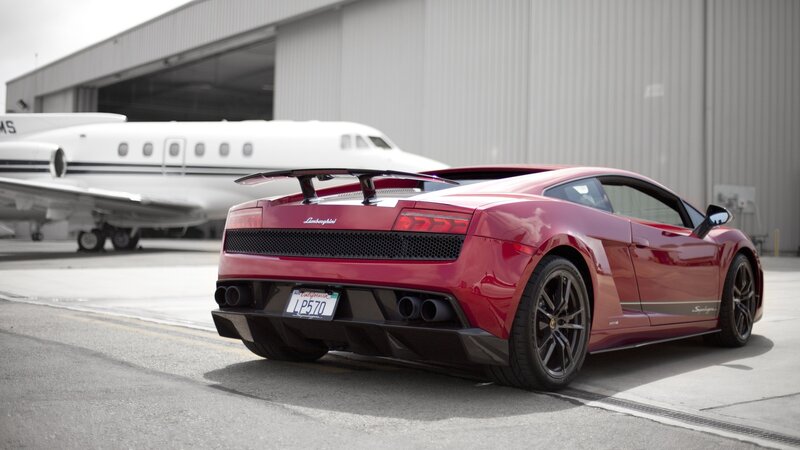 Red Lamborghini in front of private jet