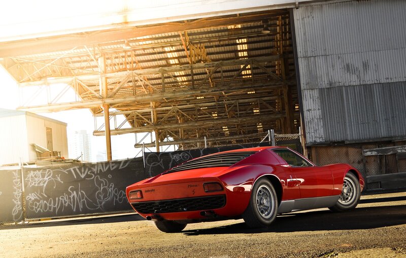 Red Lamborghini Miura in industrial setting