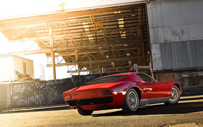 Red Lamborghini Miura in industrial setting