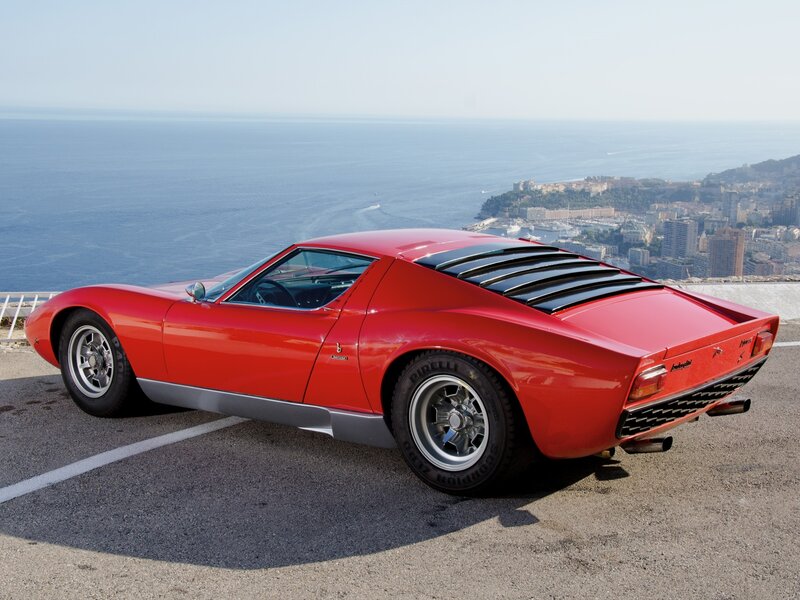 Red Lamborghini Miura on coastal road