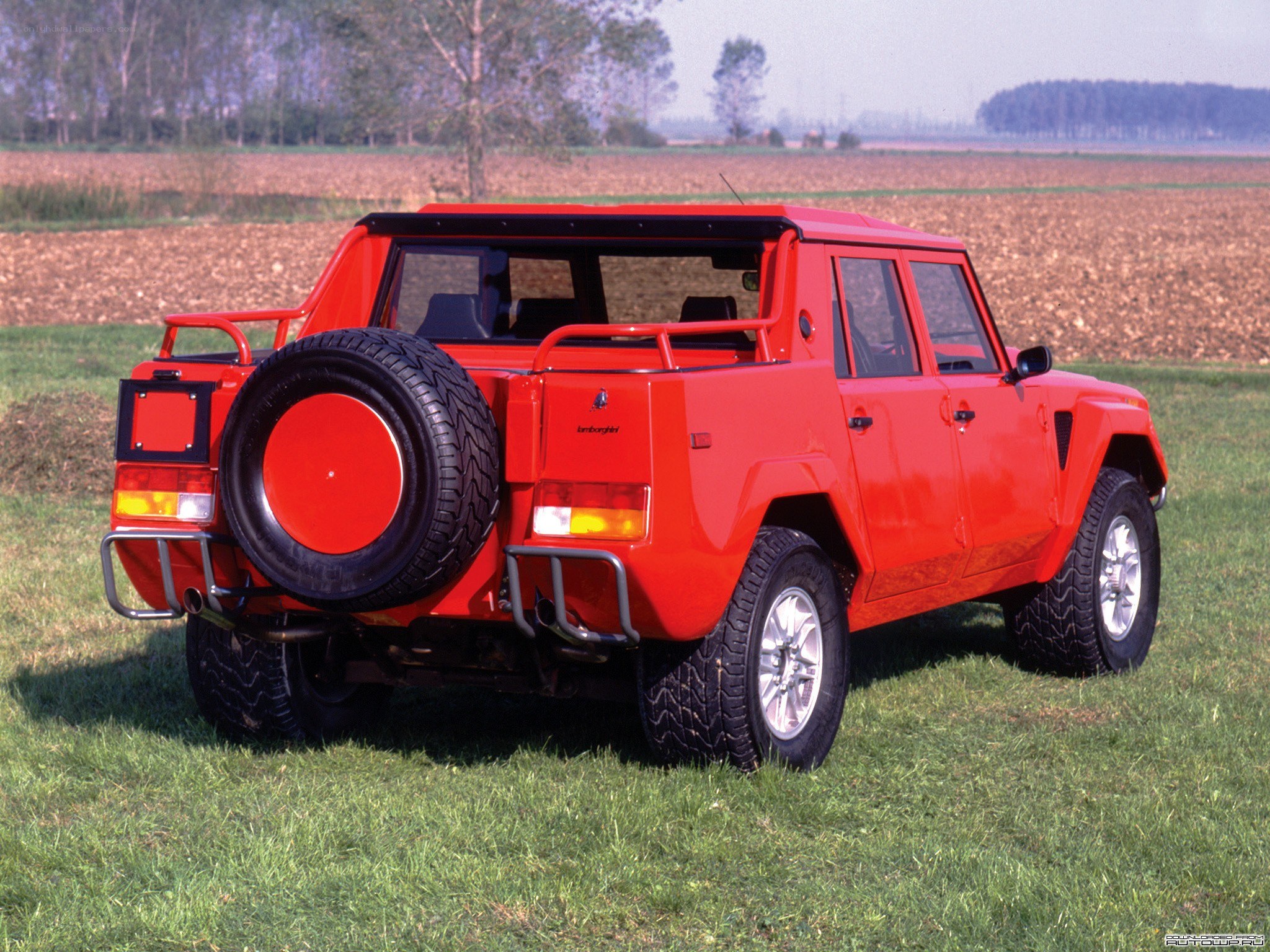 Red Lamborghini SUV in field