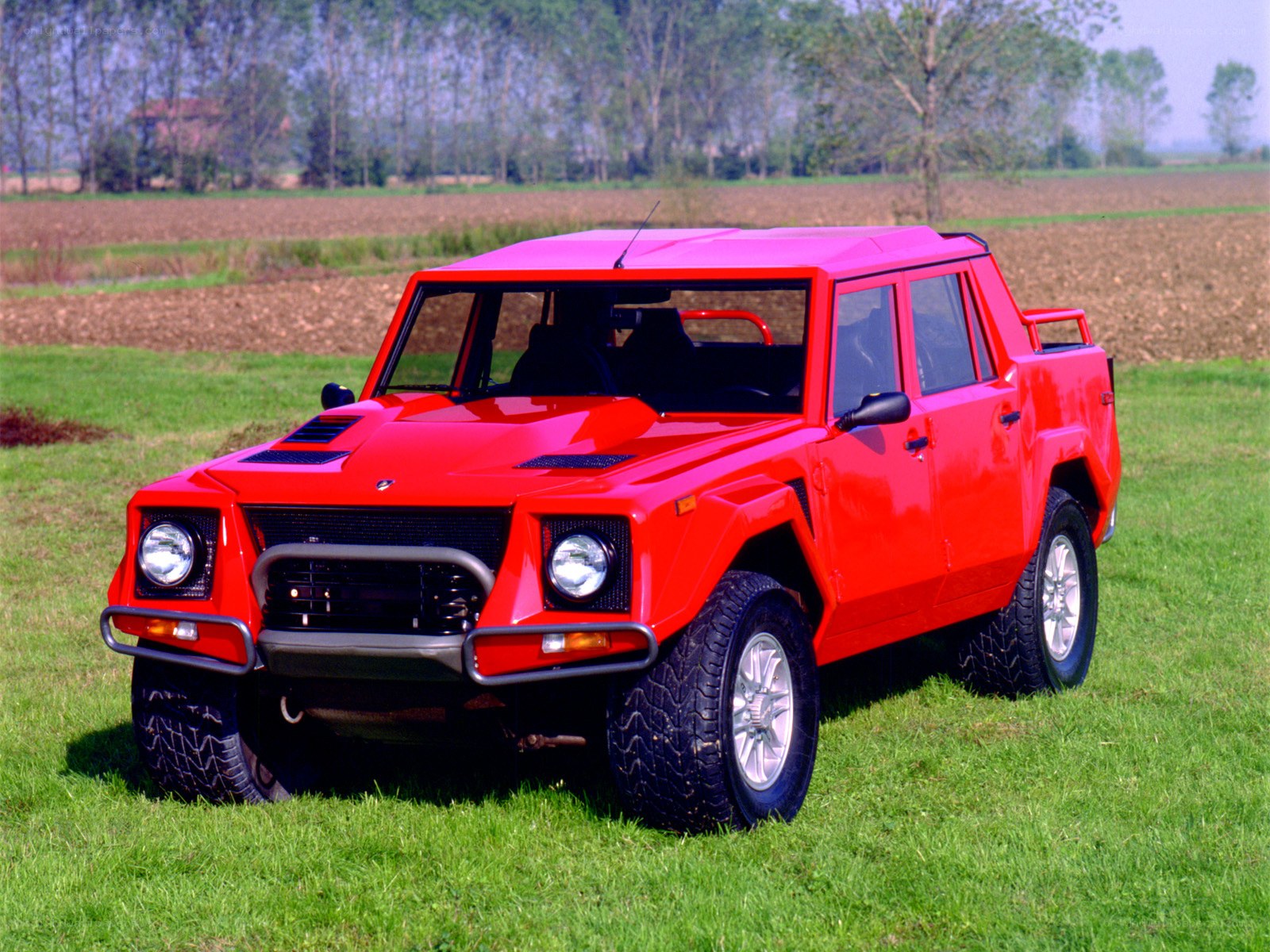 Red Lamborghini SUV in field