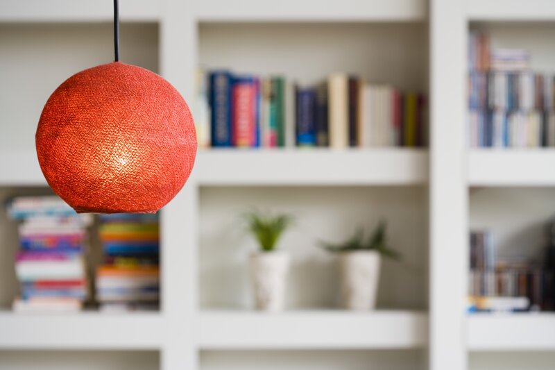Red lamp in front of bookshelf
