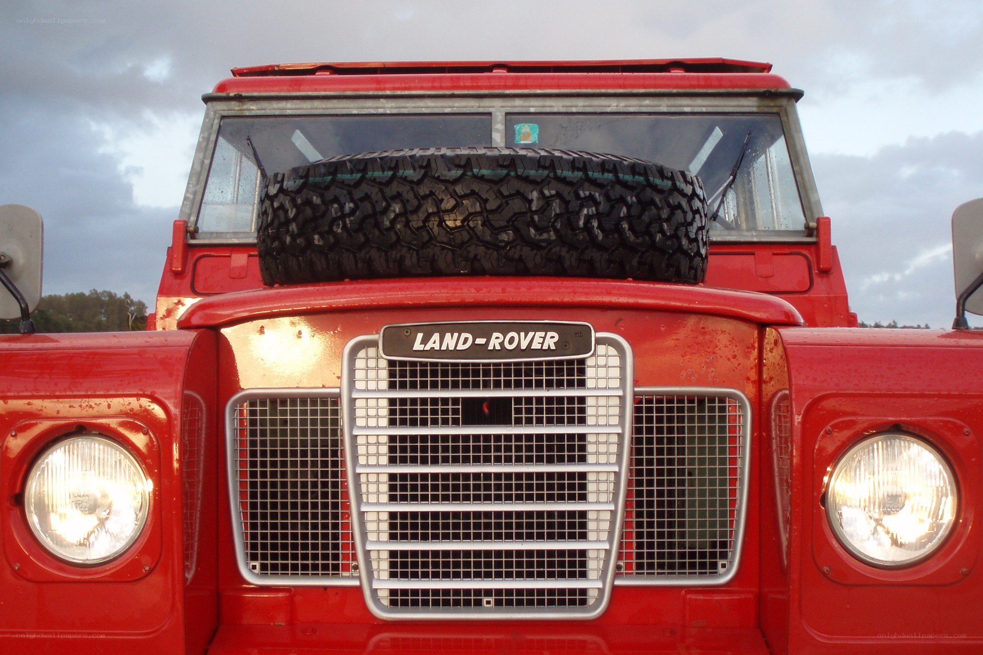 Red Land Rover with spare tire