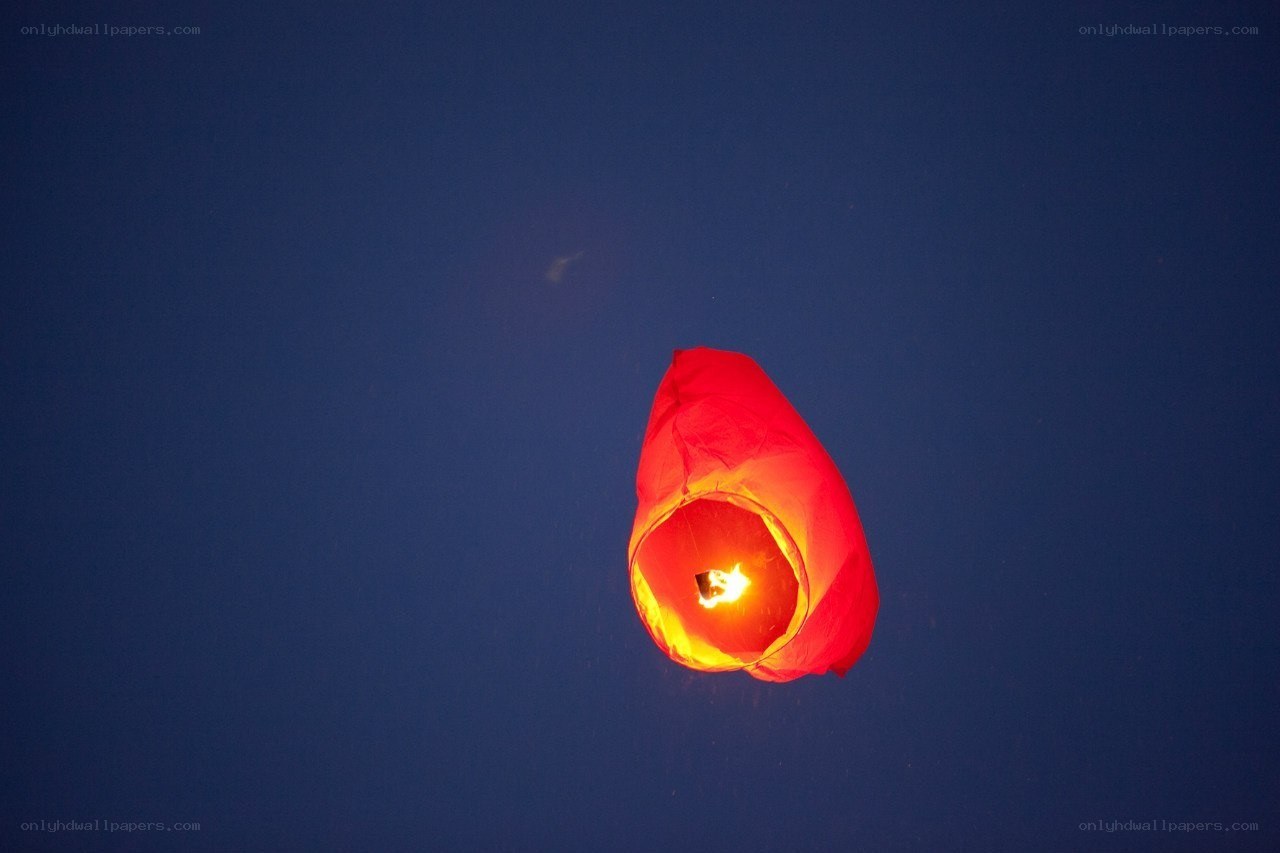 Red lantern floating in night sky