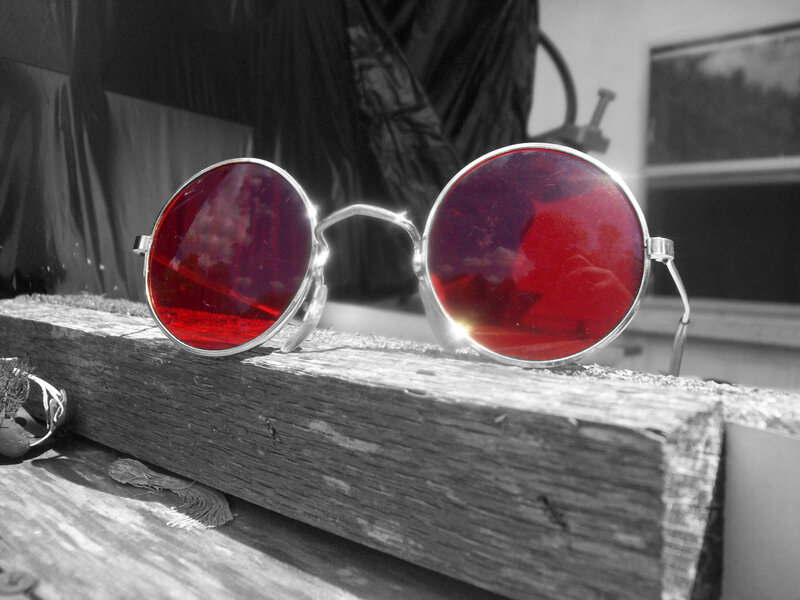 Red-lensed sunglasses on wood