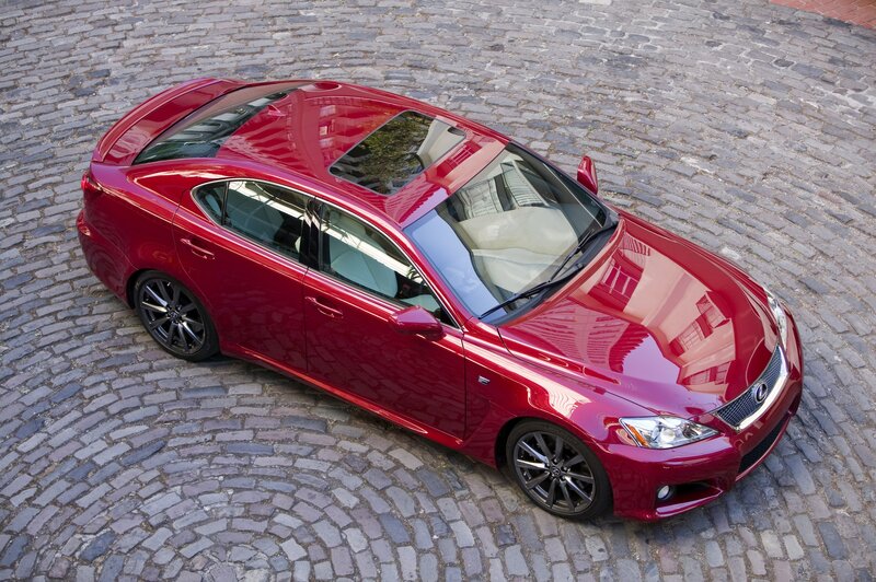 Red Lexus IS sedan on cobblestones