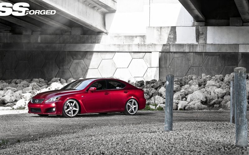 Red Lexus under a bridge