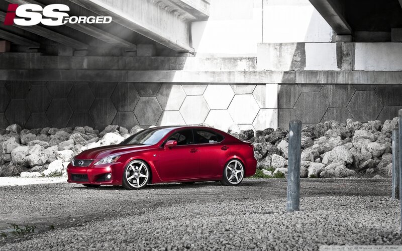 Red Lexus under a bridge