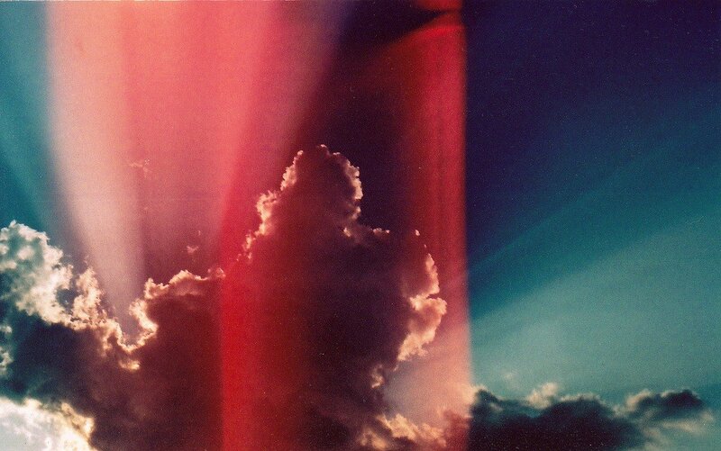 Red light beams through clouds