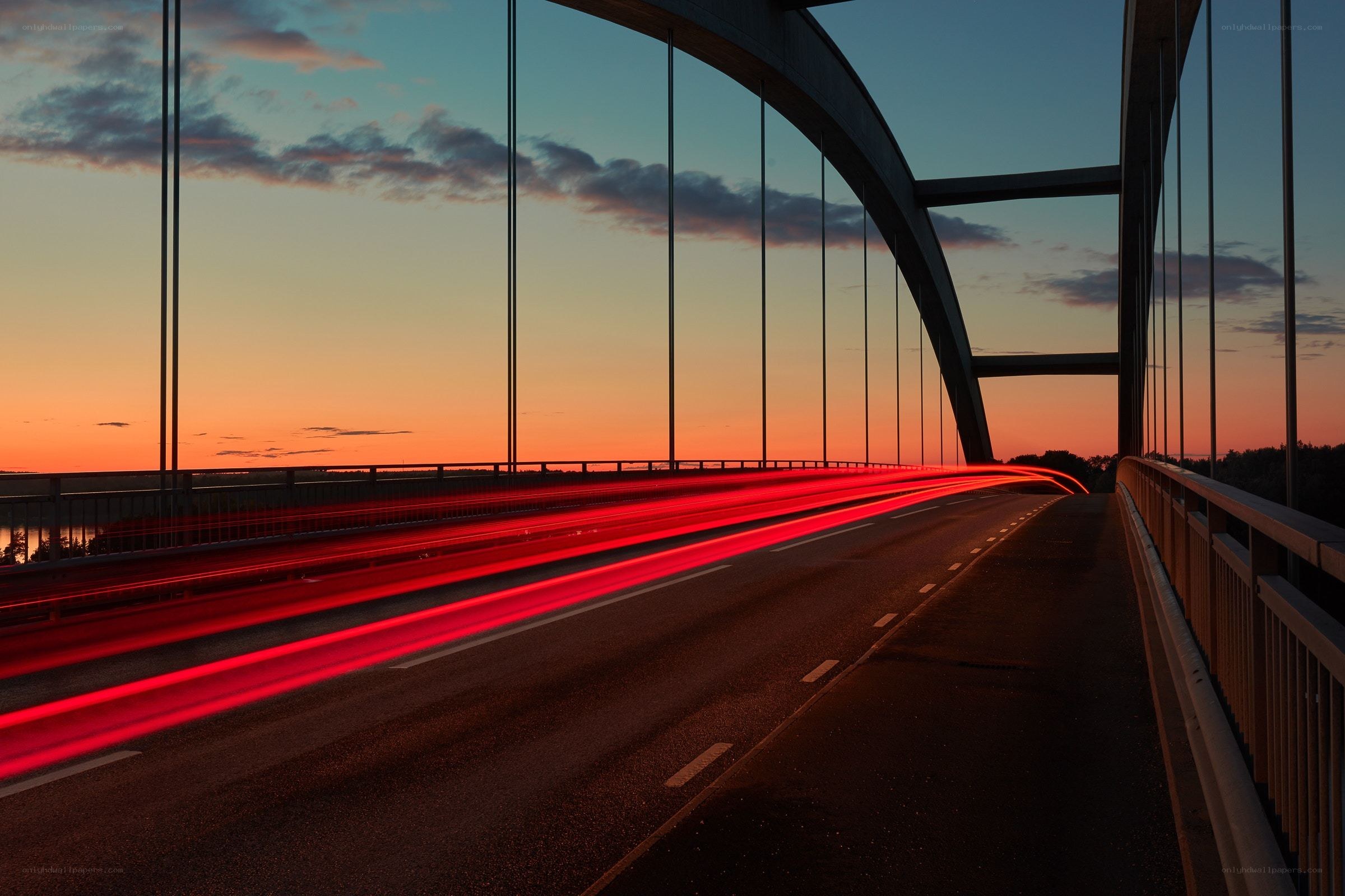Red light trails on a bridge at sunset