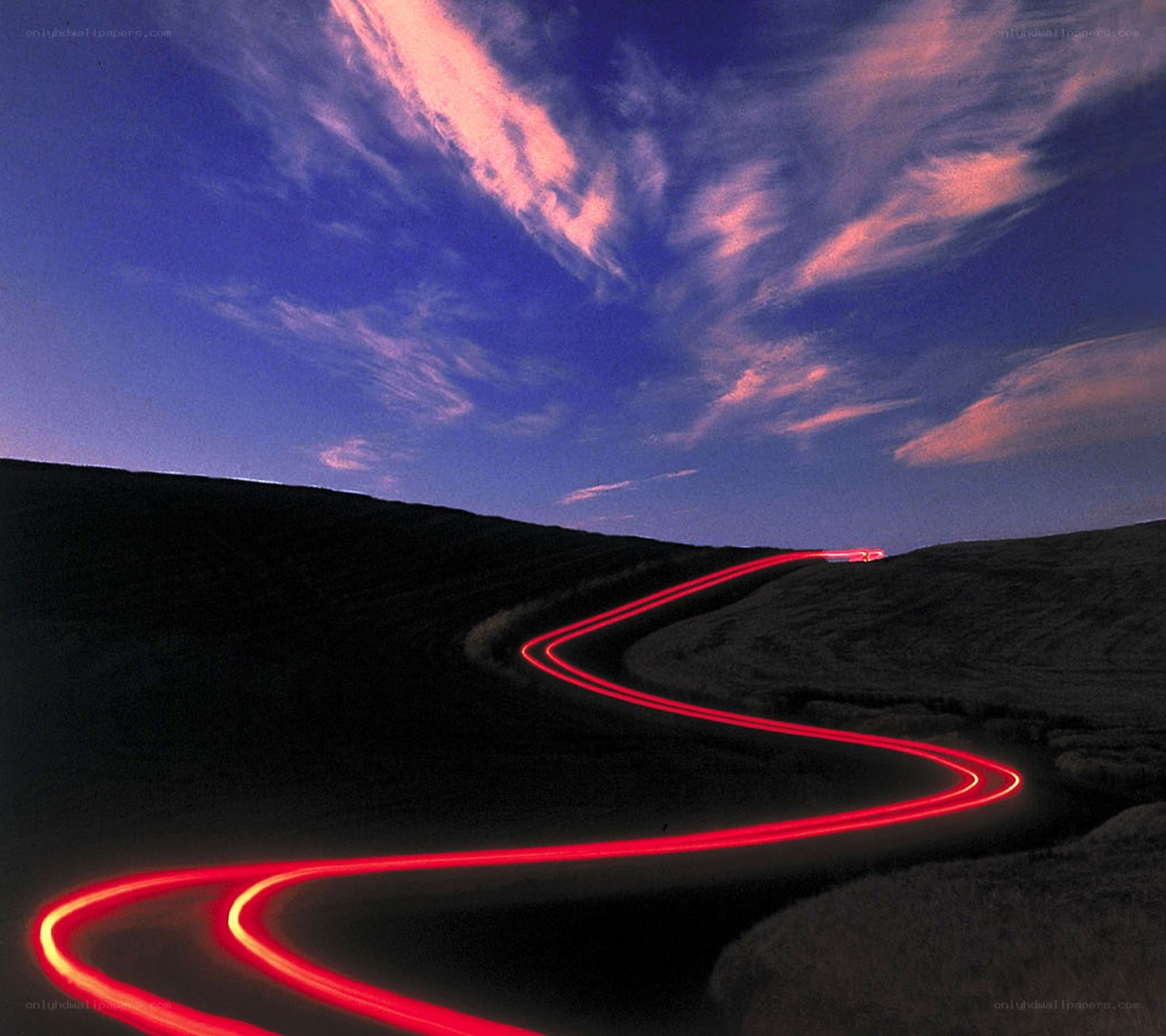 Red light trails on a winding road