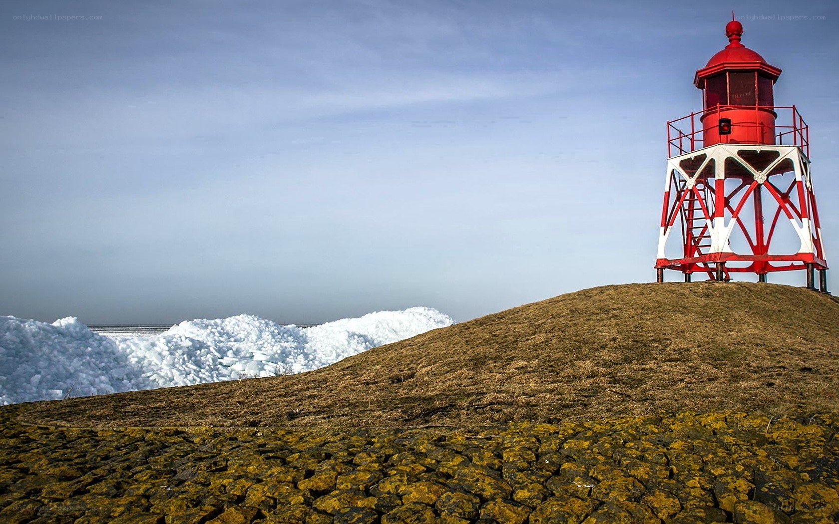Red lighthouse on a snowy hill