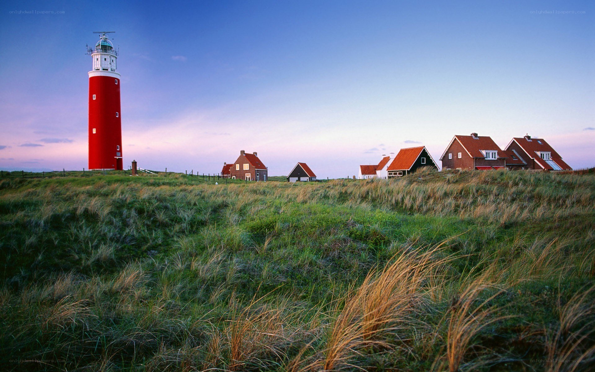 Red lighthouse on coastal dunes