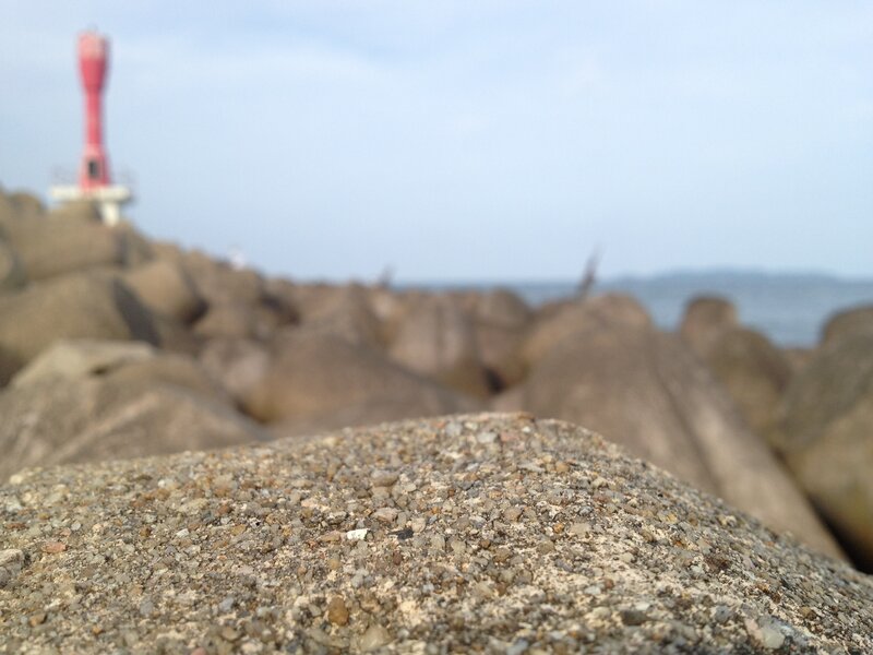 Red Lighthouse on Rocks — Gray