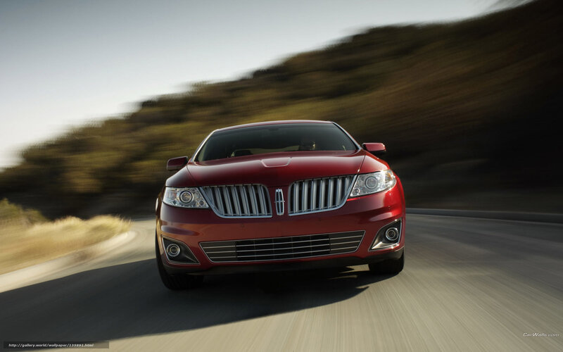 Red Lincoln driving on road