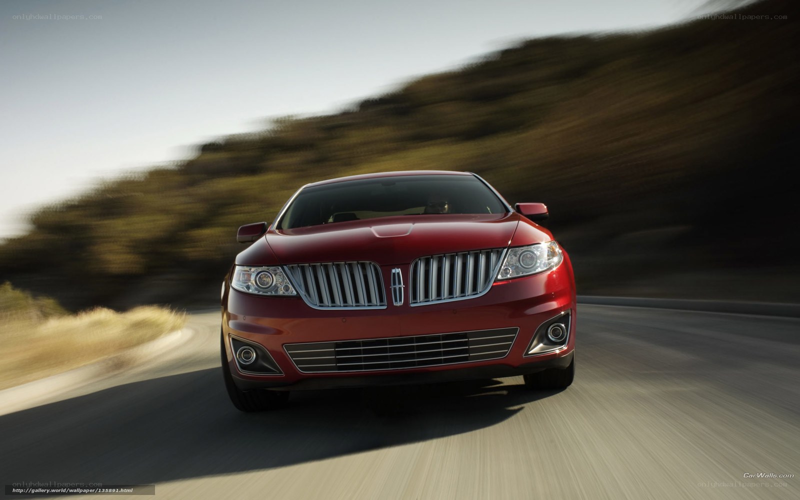 Red Lincoln driving on road
