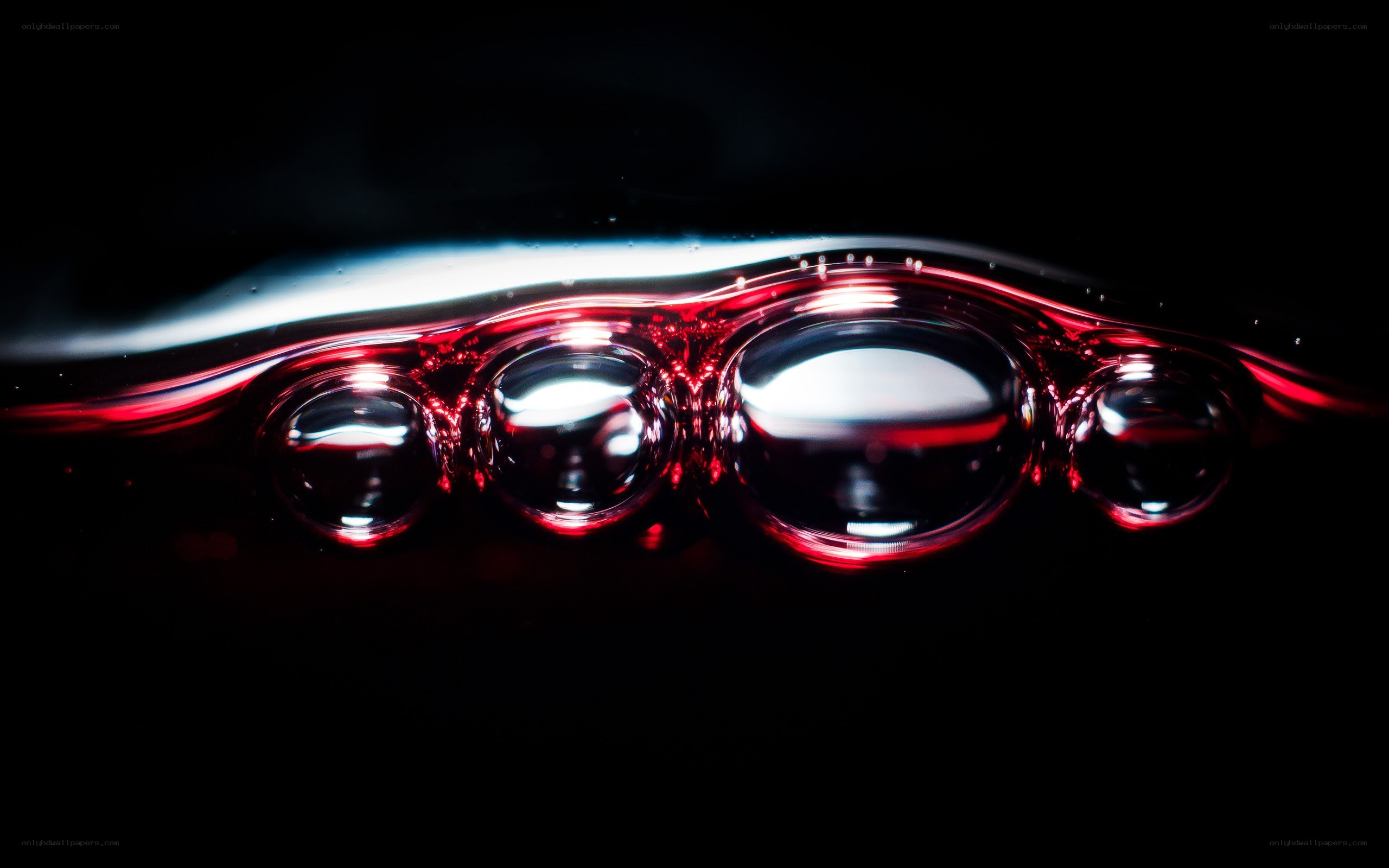 Red liquid bubbles on dark surface