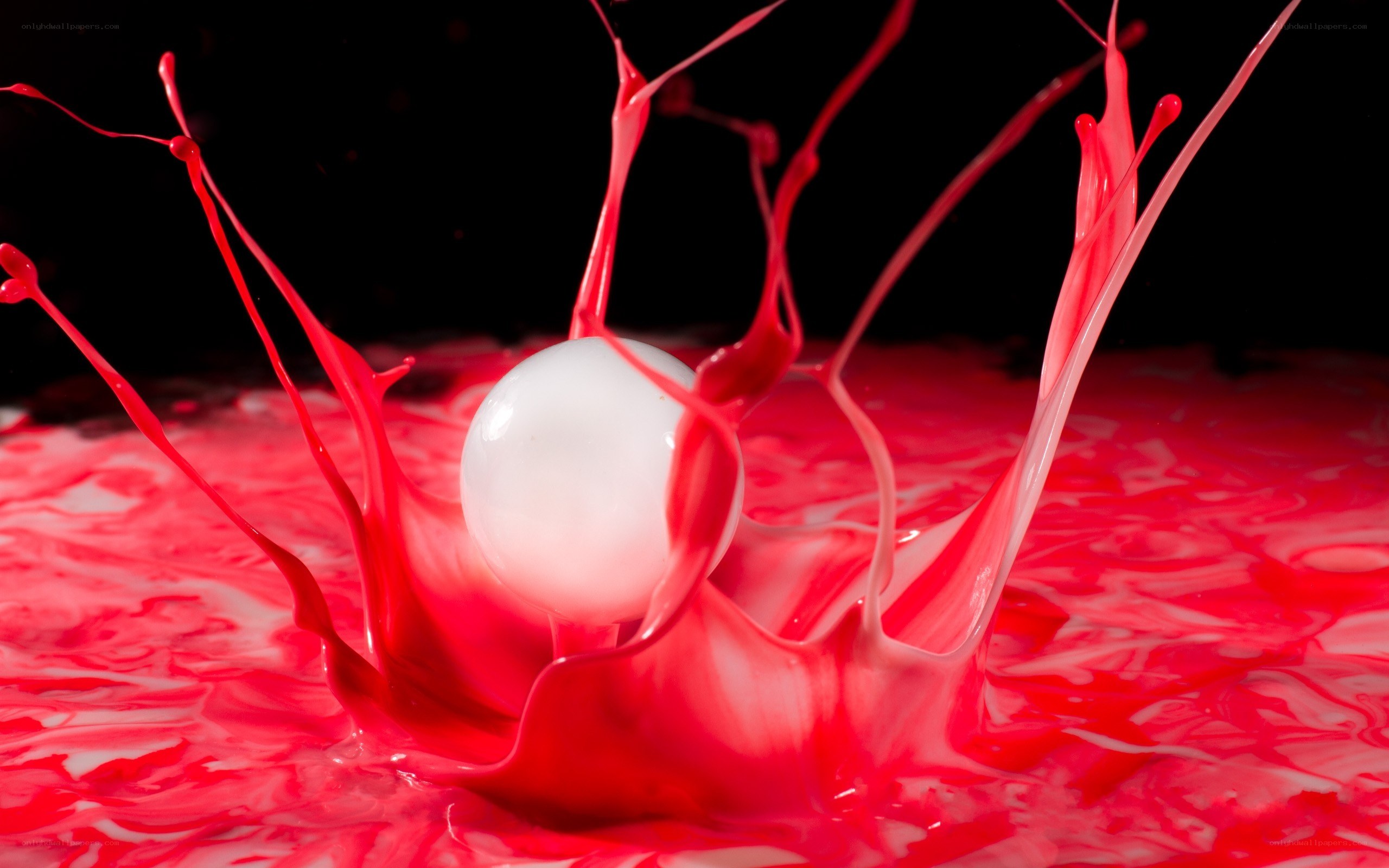 red liquid splashing around white ball