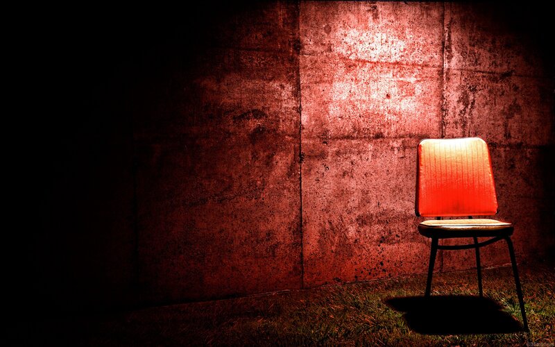 Red-lit chair in dark room