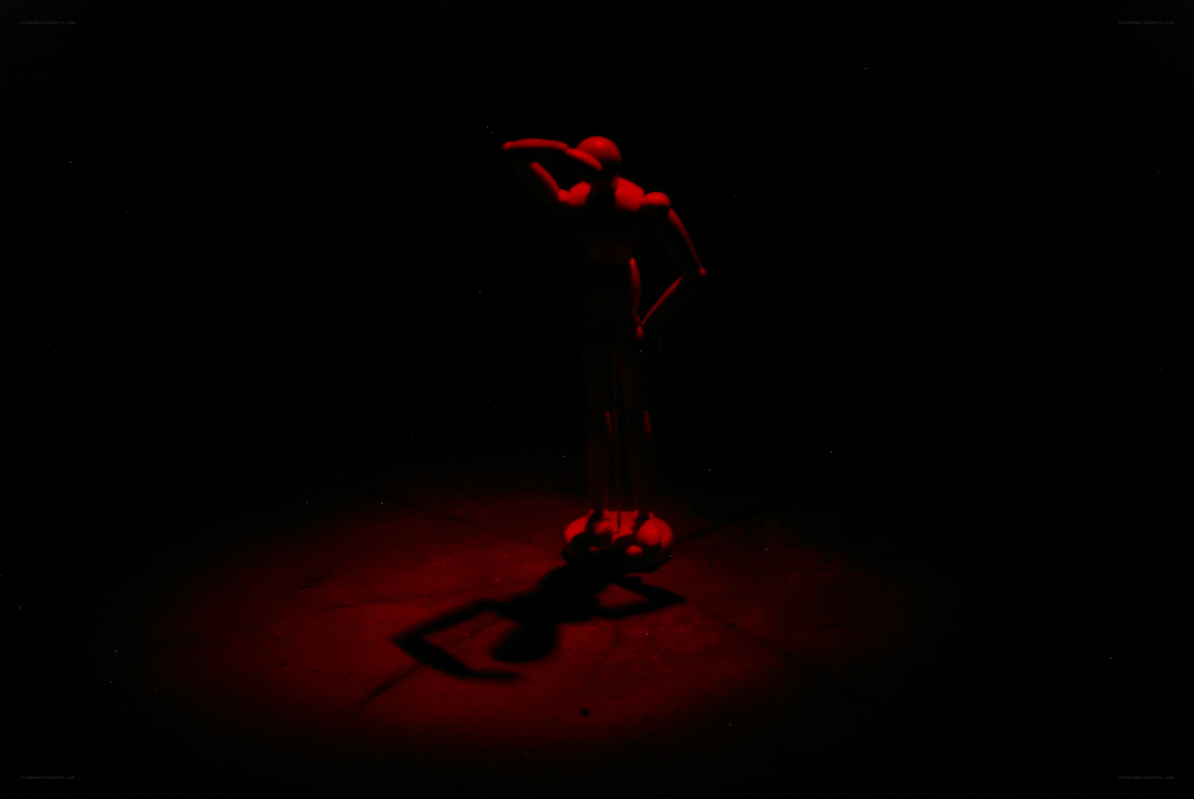 Red-lit mannequin in darkness