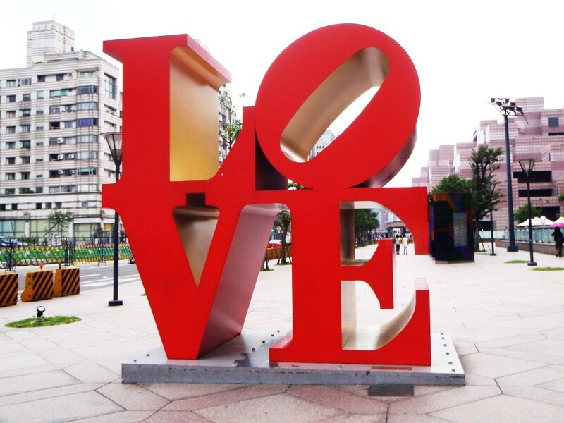 Red LOVE sculpture in city plaza