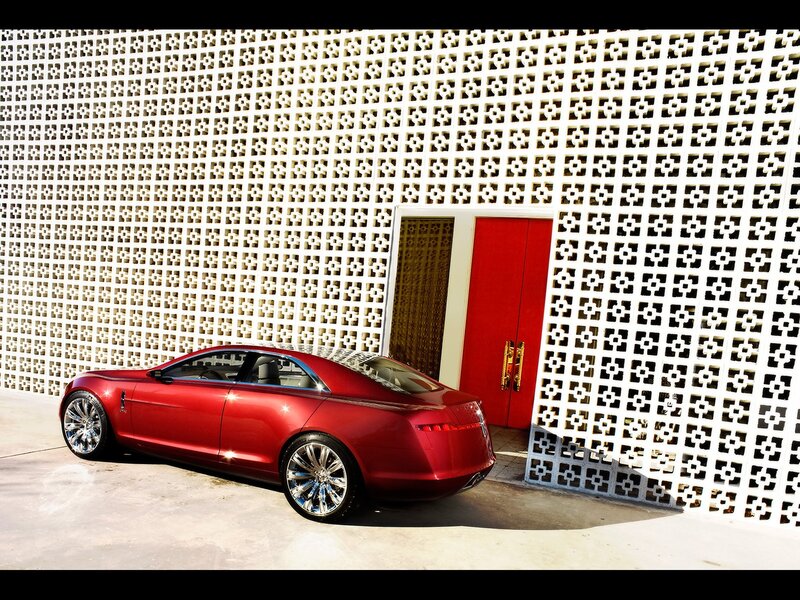 Red luxury car by a patterned wall