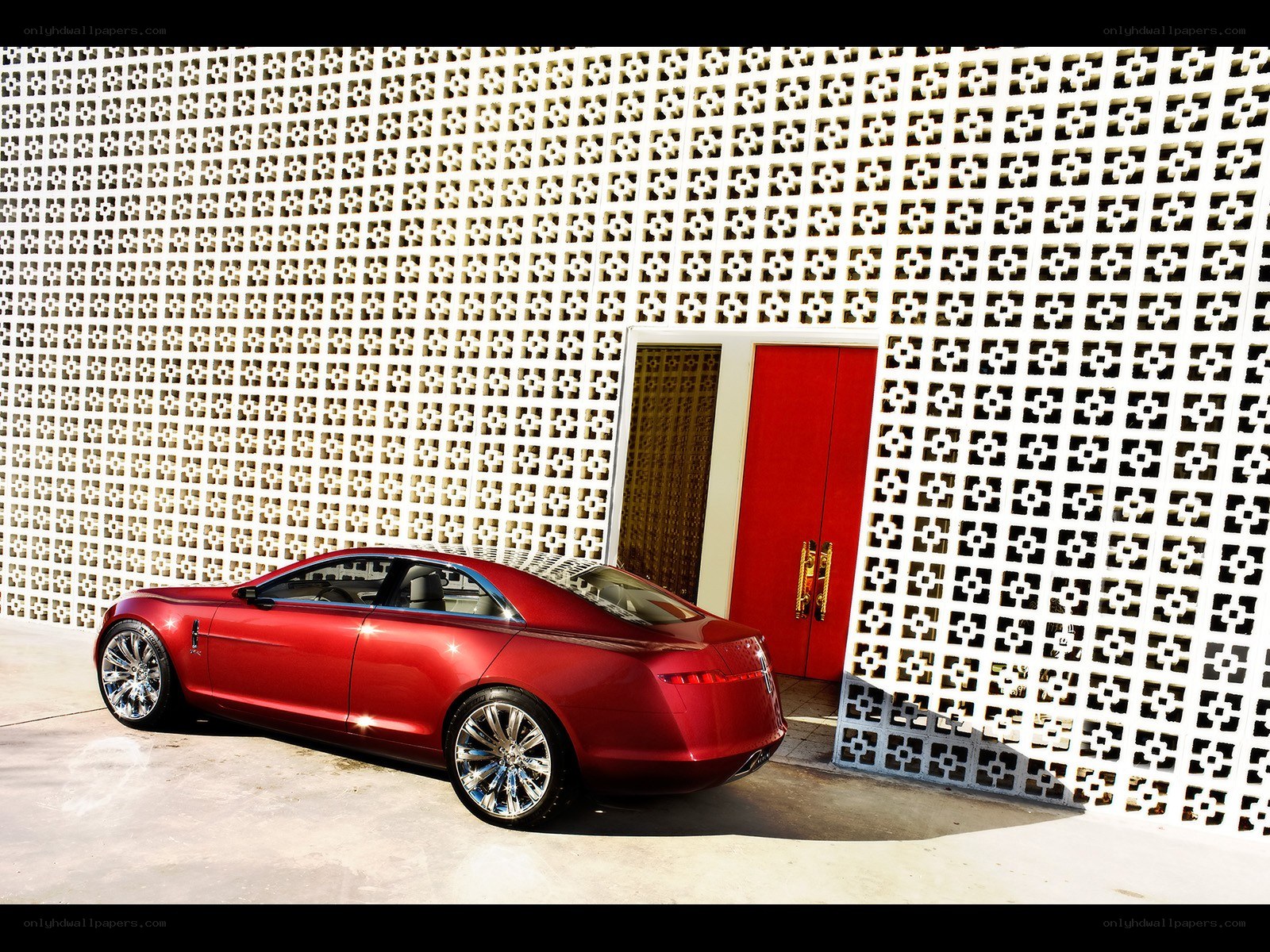 Red luxury car by a patterned wall