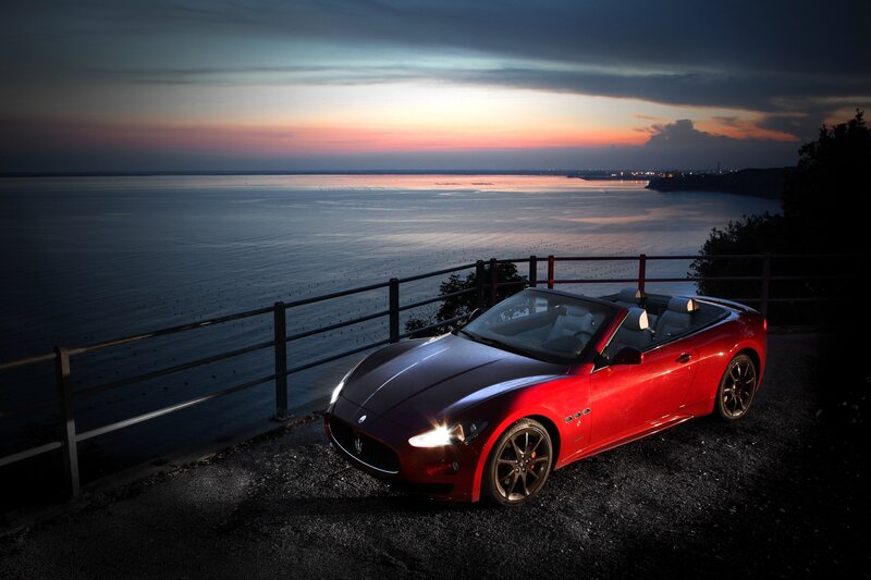 Red Maserati at sunset by the sea