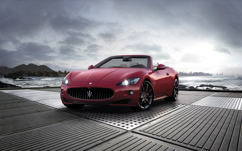Red Maserati convertible by the sea